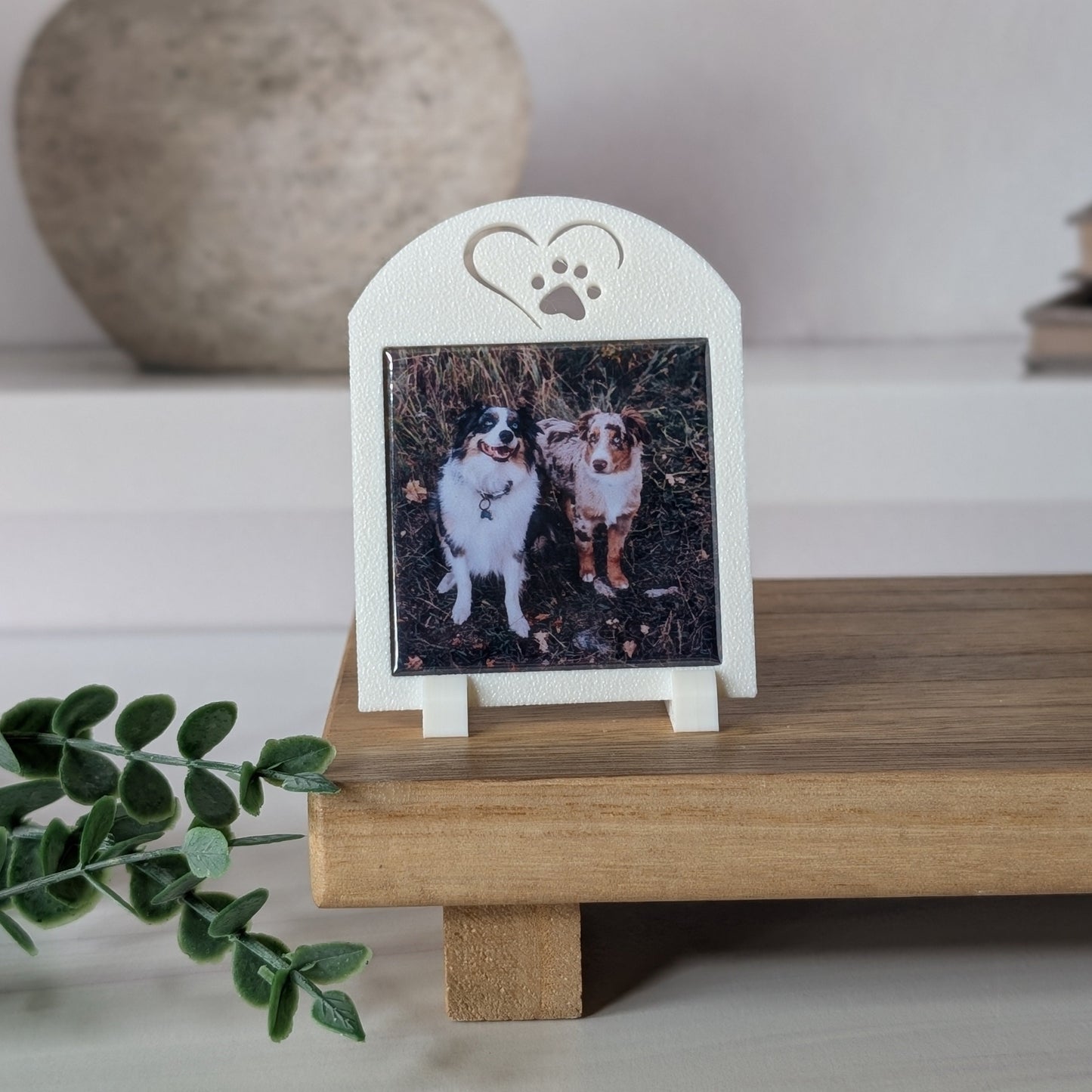 One white square photo magnet frame with an icon on the top of a heart outline around a paw.