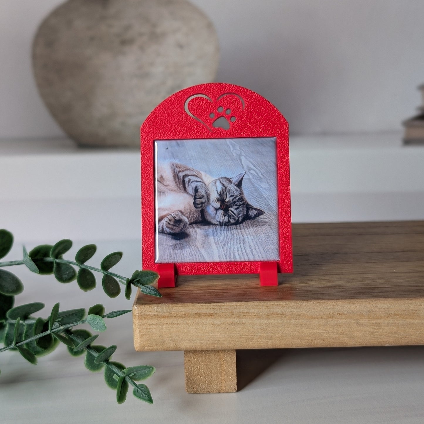 One red square photo magnet frame with an icon on the top of a heart outline around a paw.