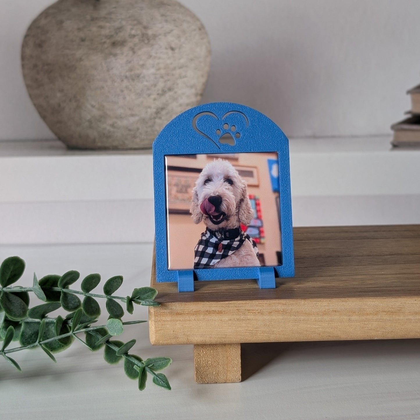 One blue square photo magnet frame with an icon on the top of a heart outline around a paw.